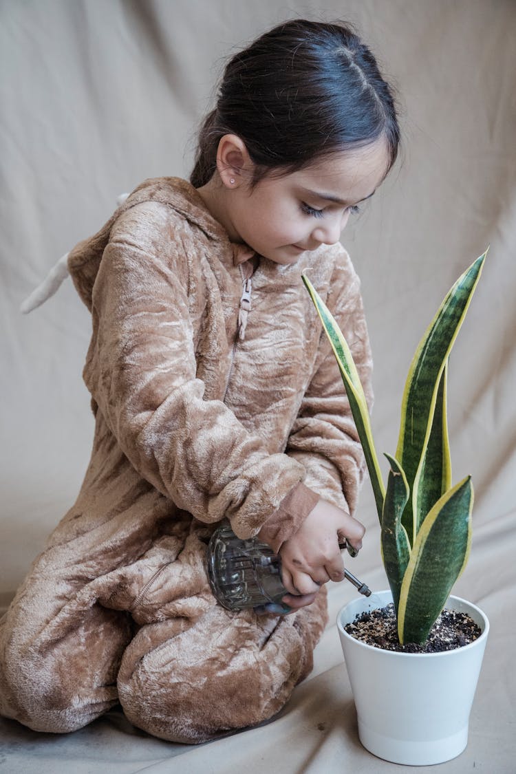 Little Girl Watering Plant