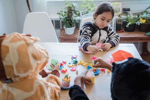 Children enjoying playtime in animal onesies with toys at home.