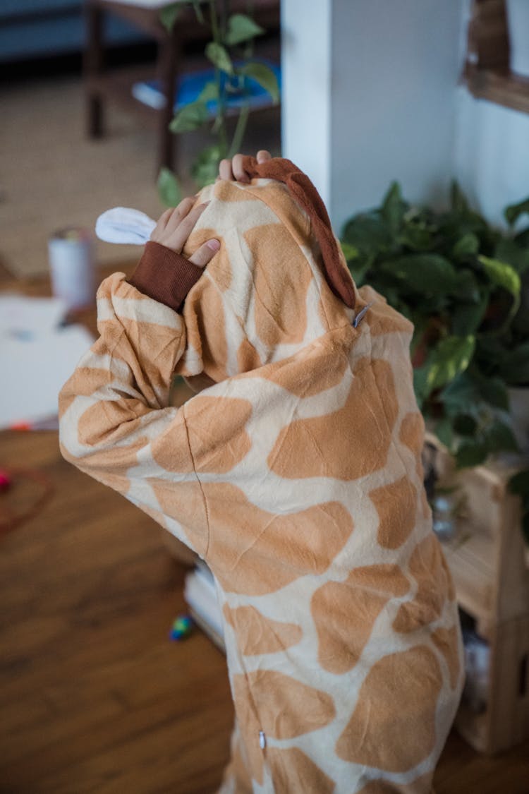 Child Wearing An Animal Onesie Playing Inside The House 