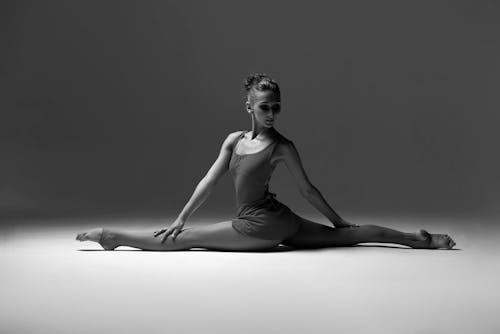 Free A graceful ballerina performing a split in a studio setting, portraying elegance and flexibility. Stock Photo