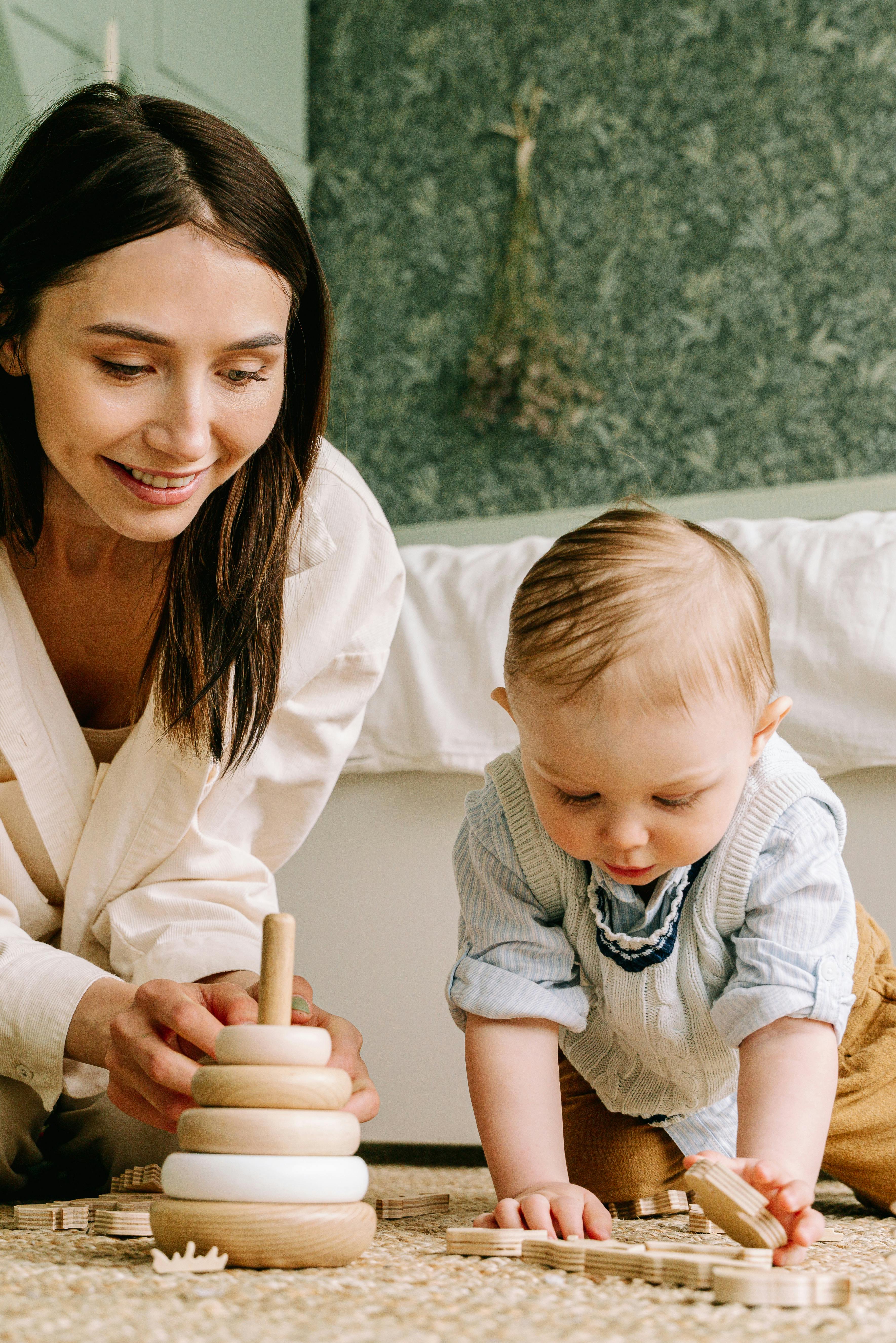 mother and baby boy playing with wooden toys