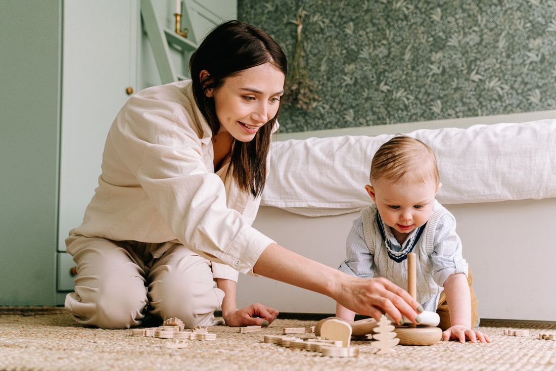 A mother and baby exploring a wooden toy together — illustrative photo