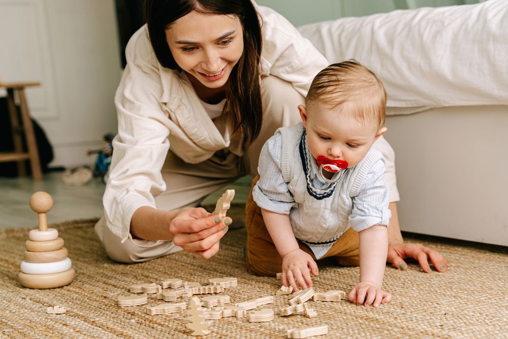 An educator playing on the floor with a baby