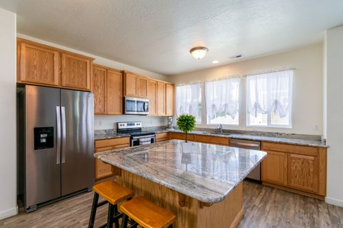 Free Bright kitchen interior featuring granite countertops and rustic wooden cabinetry with a modern stainless steel finish. Stock Photo