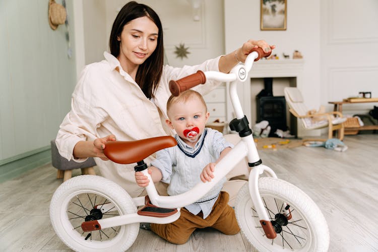 A Mother And Baby Holding A Bike 