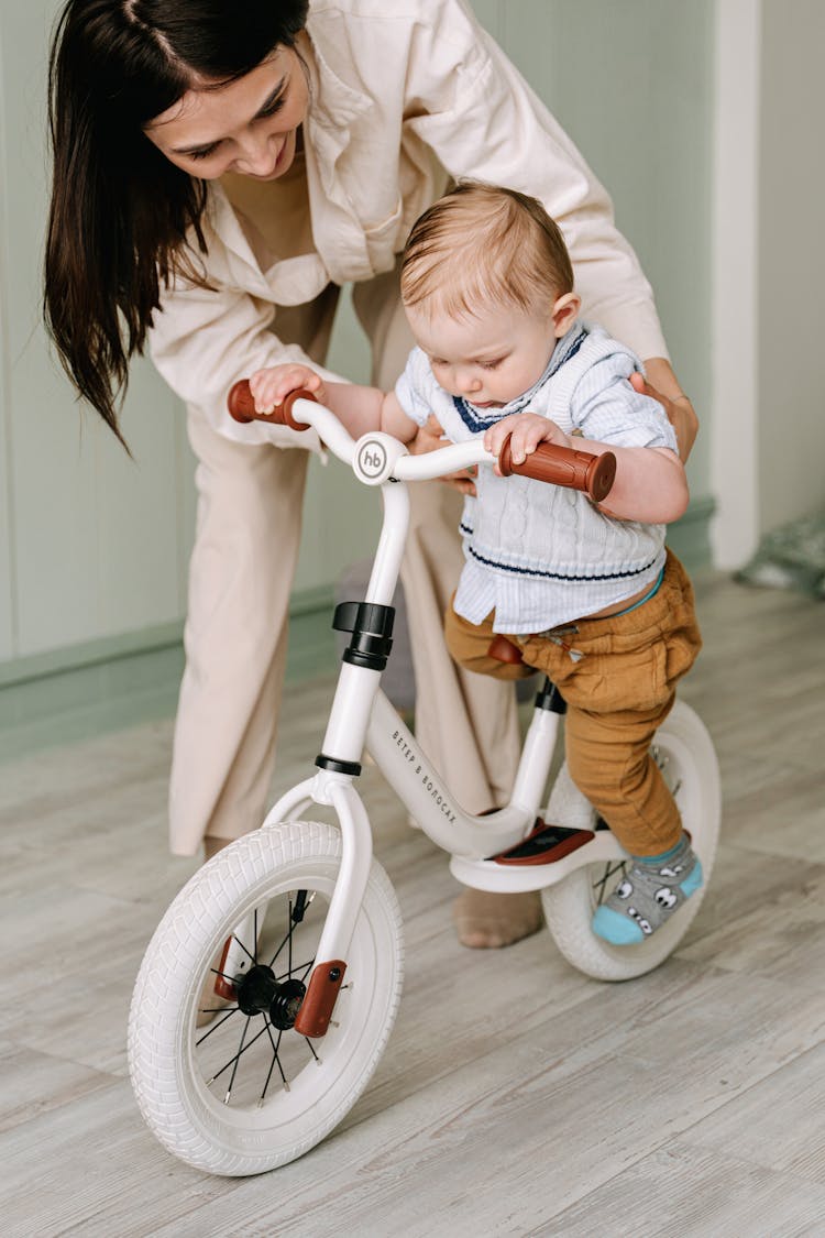 Woman Holding A Baby Seated On A Bicycle