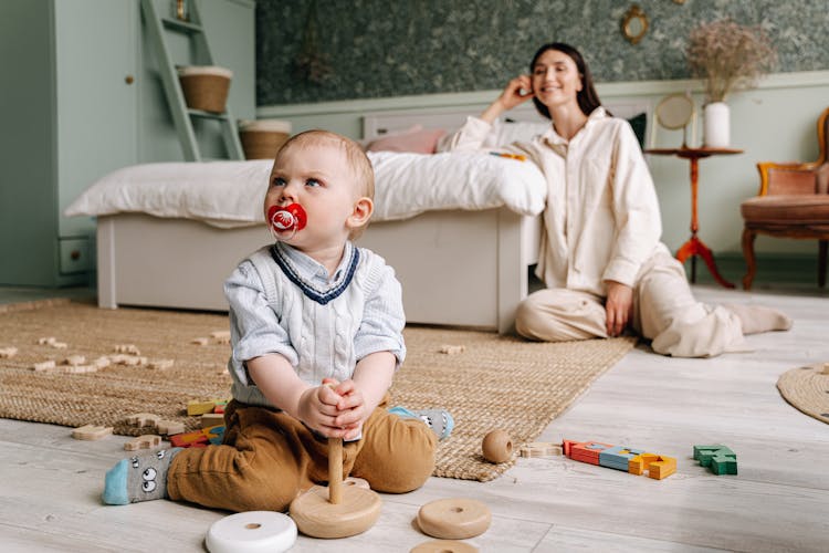 Baby Boy Playing With Wooden Blocks On Floor