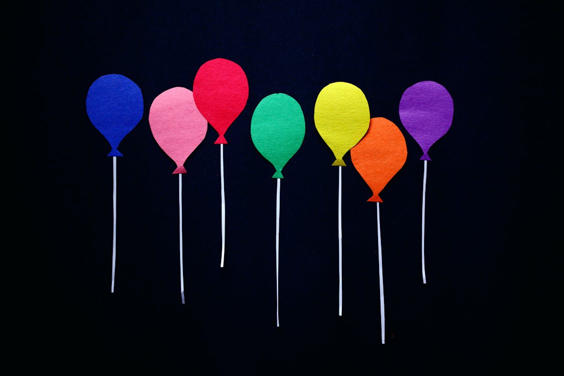 Free Colorful Cutout Balloons on Black Background Stock Photo