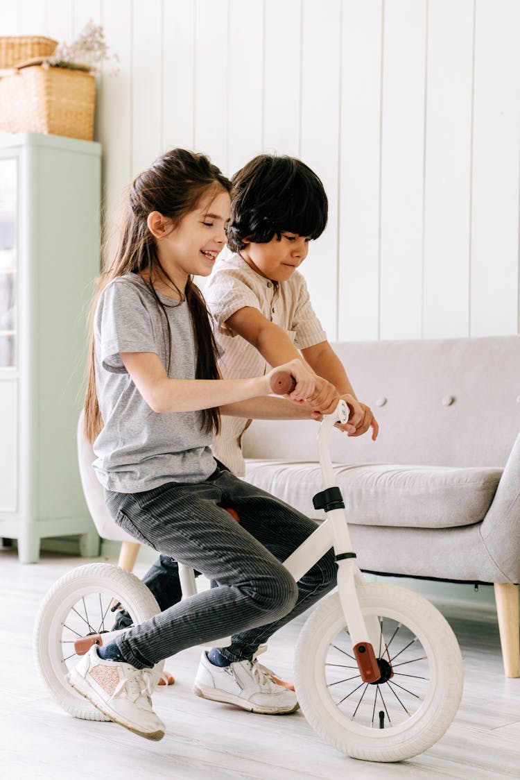 A Girl Riding A Bicycle Inside The House 