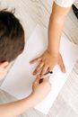 High-Angle Shot of a Child Tracing Another Child's Hand on a Paper