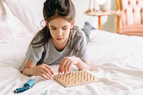 A Girl in Gray Shirt Playing Board Game