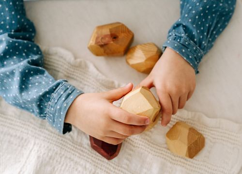 Free Close-up of a child's hands playing with wooden geometric blocks, highlighting mindfulness and creativity. Stock Photo