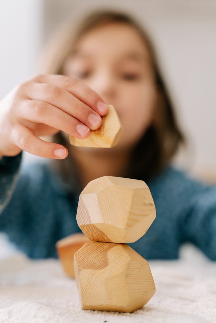 Shallow Focus Photo Of A Kid Playing Wooden Blocks