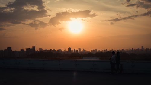 Free Beautiful sunset over city skyline with silhouettes, creating a serene urban scene. Stock Photo