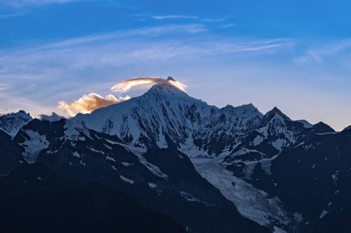 Free Stunning view of snow-capped mountains with a dramatic sky during dusk. Stock Photo