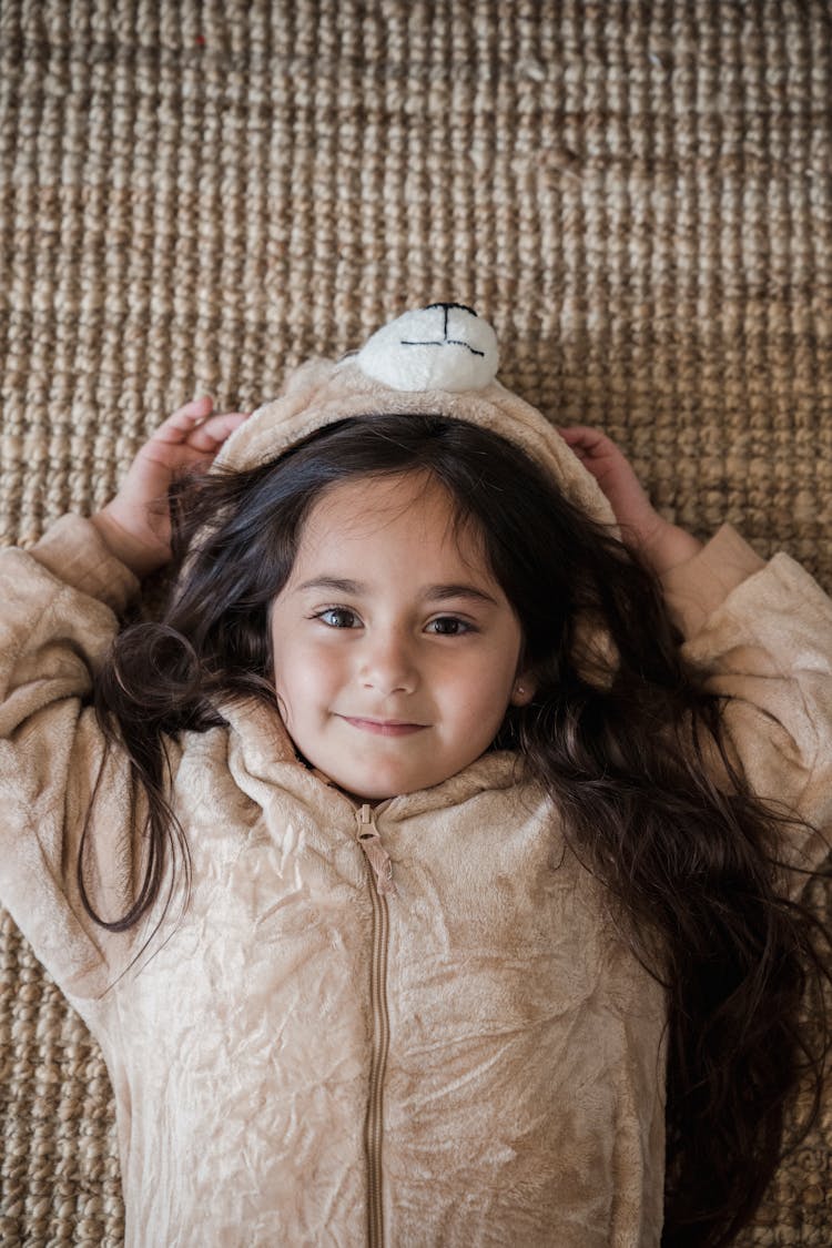 A Girl Lying Down And Wearing A Onesie