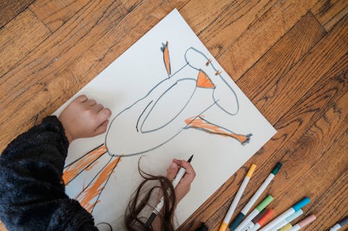 A Child Drawing on a Paper