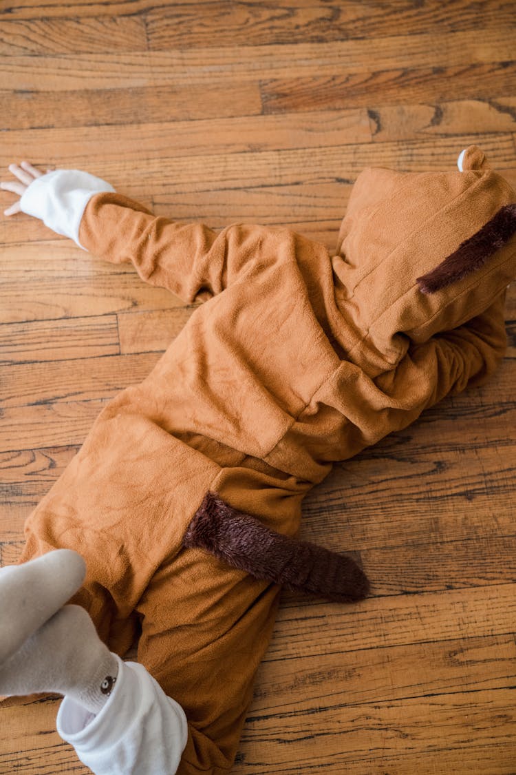 Child In An Animal Onesie Lying On The Floor 