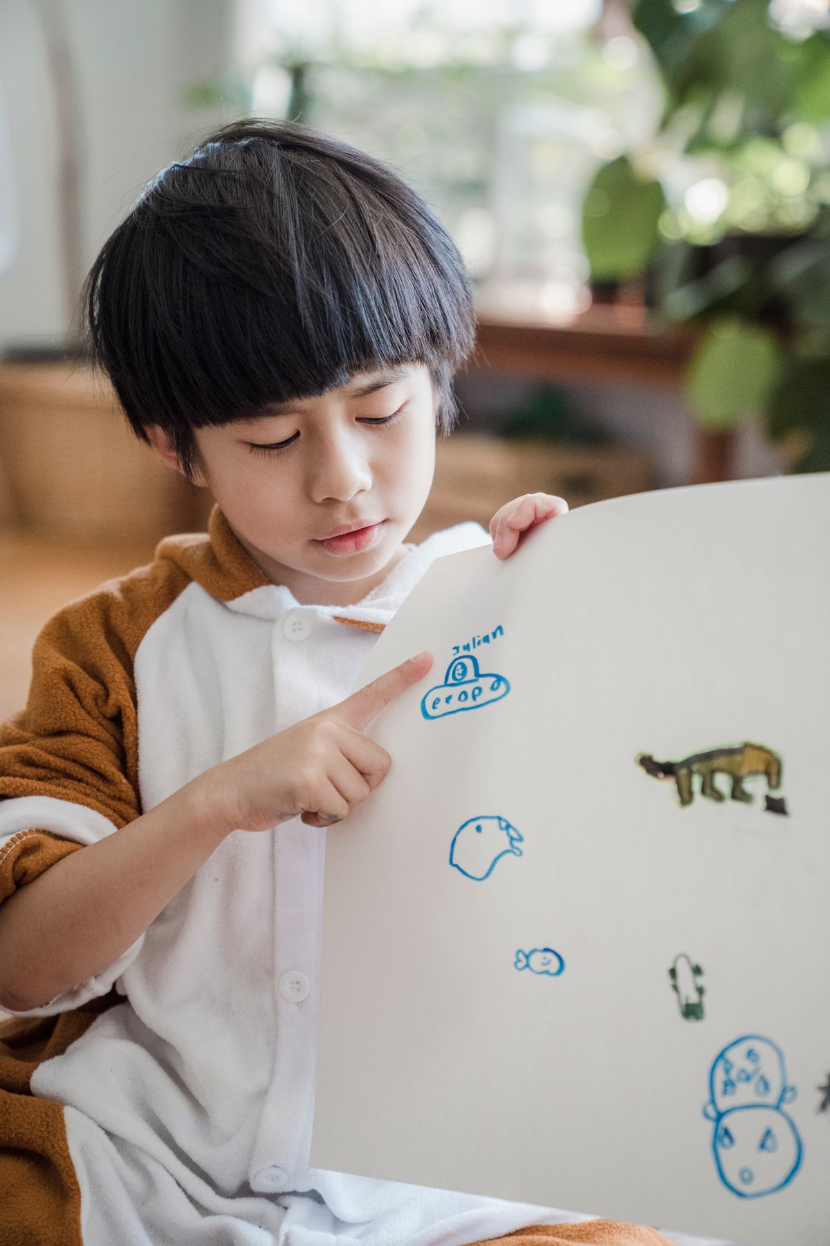 Young child in a cozy setting focused on drawing a ladybug