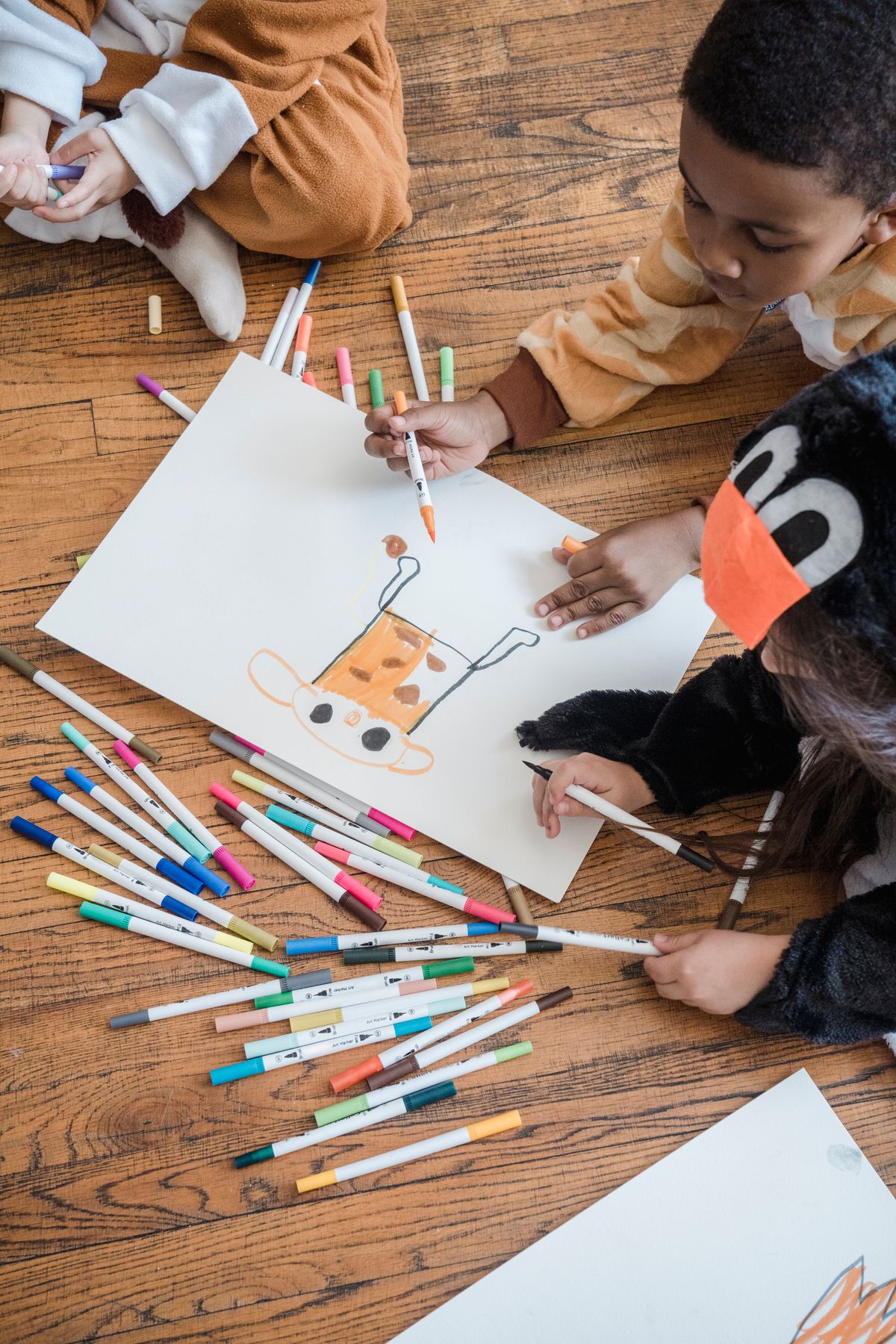 Kids in animal costumes enjoying a drawing session making a bear cub