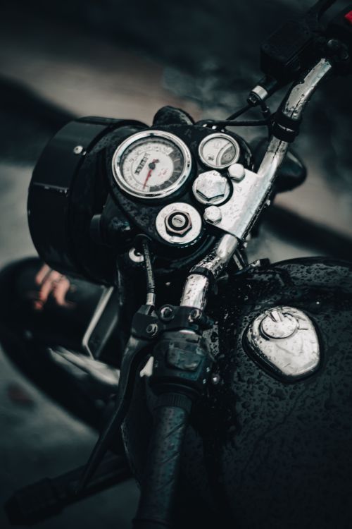 Free A detailed shot of a motorcycle dashboard featuring water droplets on the speedometer and controls. Stock Photo