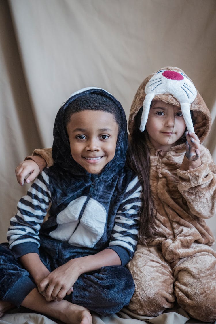 A Boy And A Girl In Animal Costumes Looking At Camera While Smiling