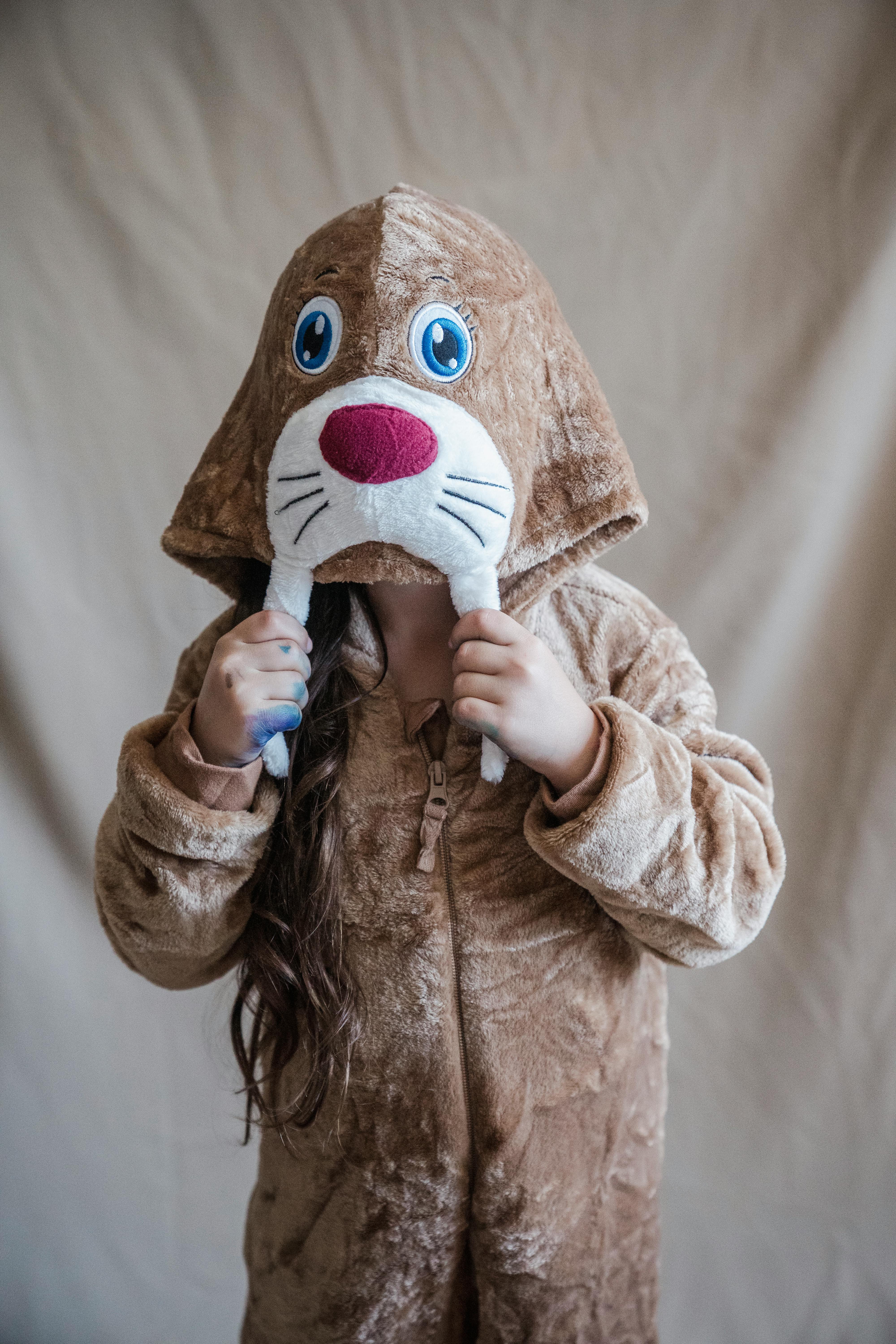 little girl hiding face in hood of walrus onesie