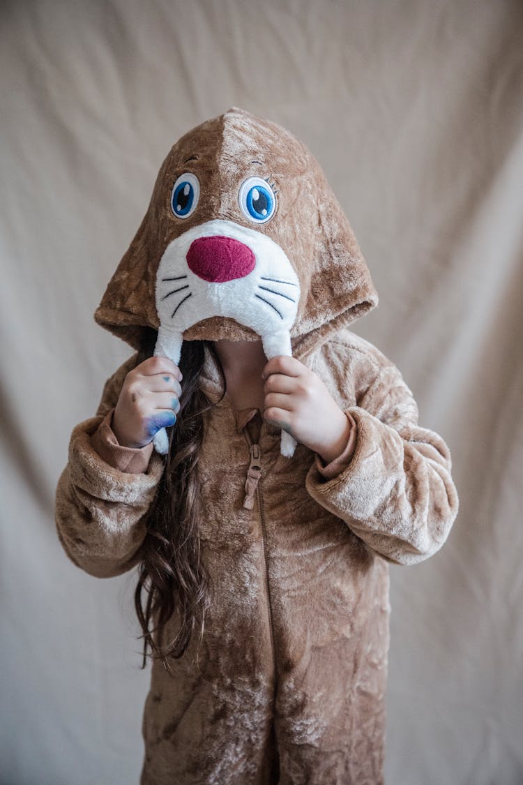 Little Girl Hiding Face In Hood Of Walrus Onesie