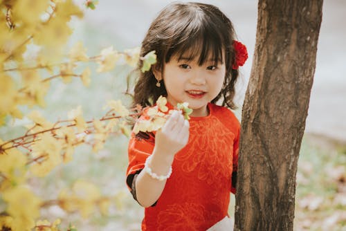 Portrait of a Cute Little Girl Standing by a Tree