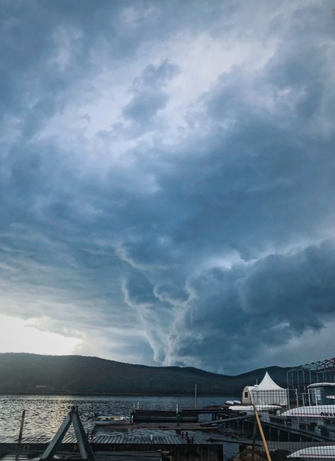 Dramatic stormy sky above a pier in Russkiy, Russia, showcasing an intense cloud formation.
