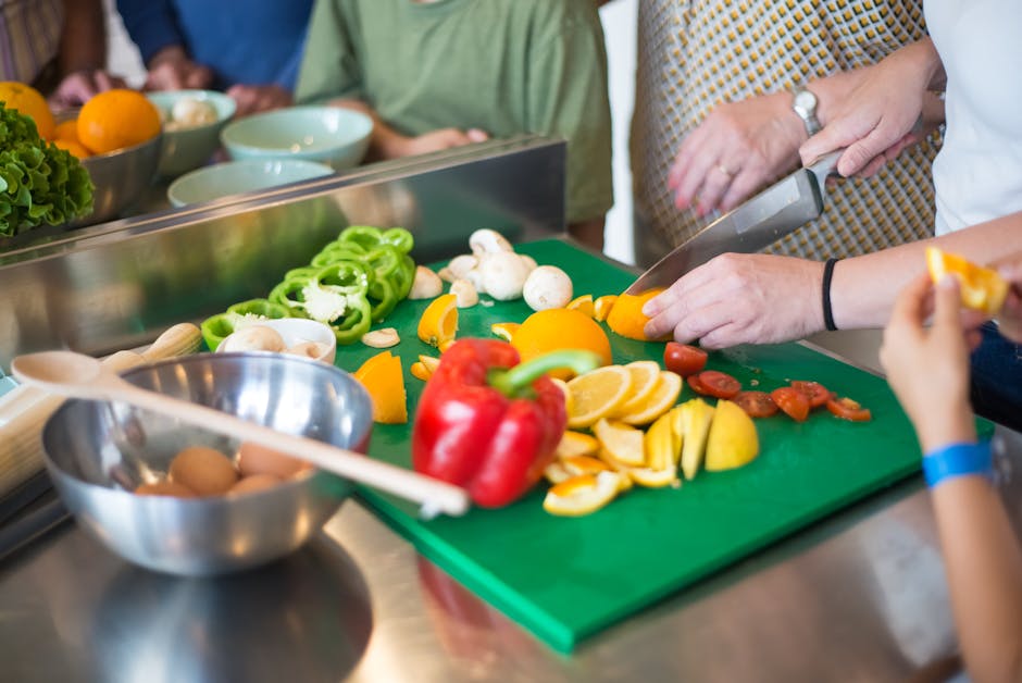 A lively cooking class with people chopping vegetables and smiling. Photographed by Kampus Production