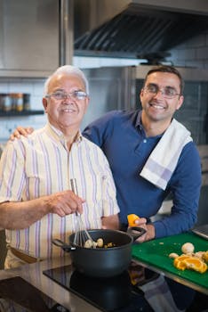 Father and son cook happily together in a modern kitchen, showcasing family bonding and culinary enjoyment.