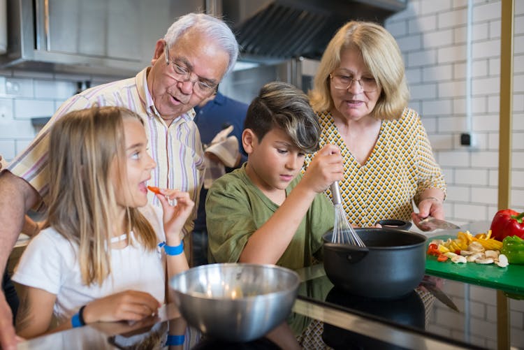 Elderly Woman Teaching Boy How To Cook 