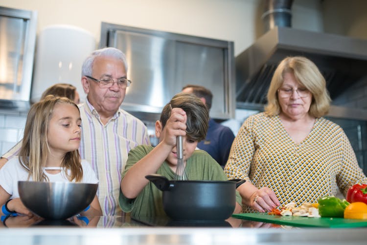 A Low Angle Shot Of A Family Preparing Food In The Kitchen