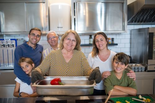 Free A joyful family gathers in their modern kitchen, bonding while cooking a meal. Stock Photo