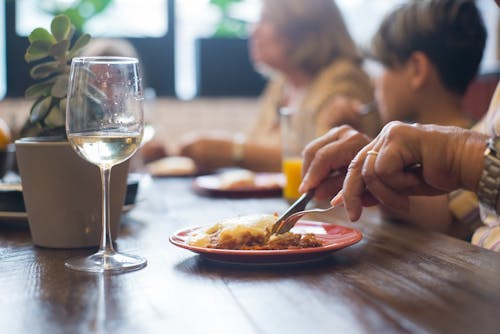 Free A Glass of Wine Near the Ceramic Plate with Food Stock Photo