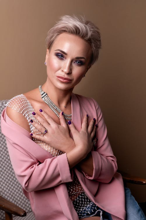 Woman in Pink Jacket with Hands on Chest