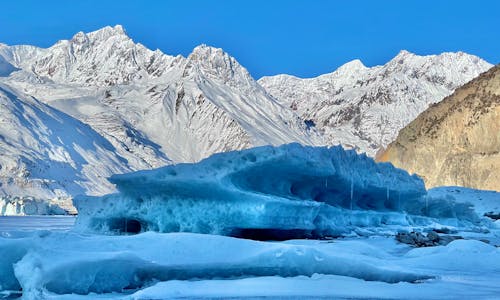 Glacier Beside Snow Covered Mountains