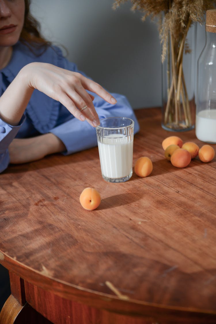 A Woman Touching The Rim Of A Glass Cup