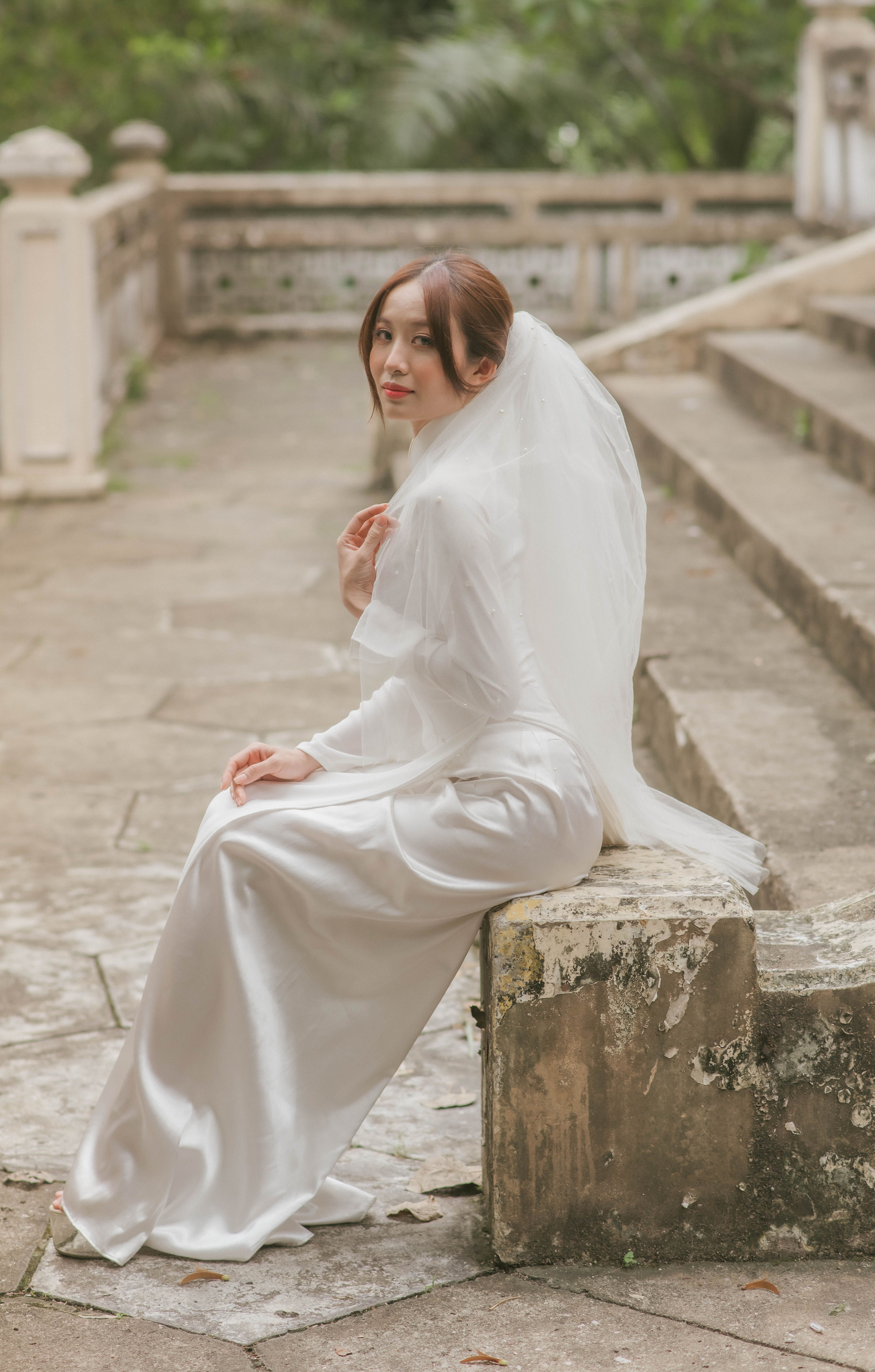 Woman in White Long Sleeved Dress Sitting on Gray Concrete Bench · Free ...