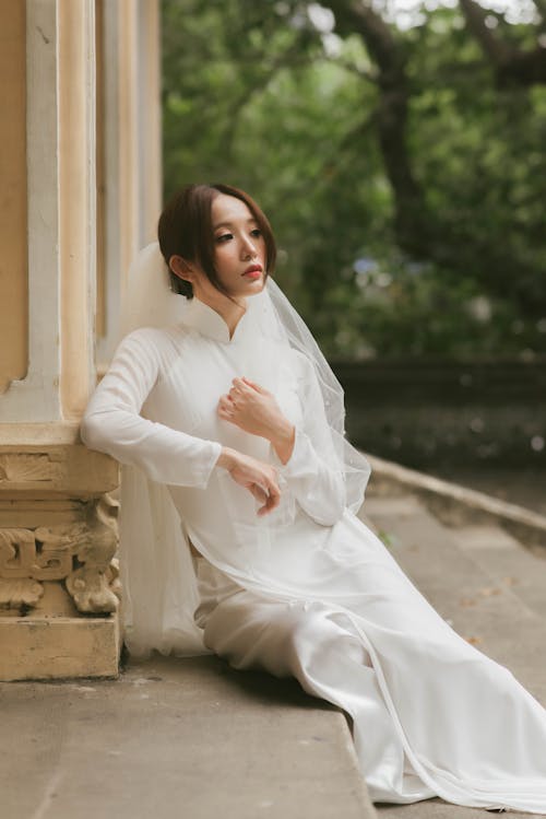 Free Bride in her Wedding Dress Sitting on the Stairs and Leaning on the Post Stock Photo