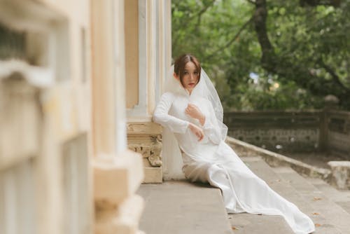 Free Woman in her Wedding Dress Sitting on the Stairs Stock Photo