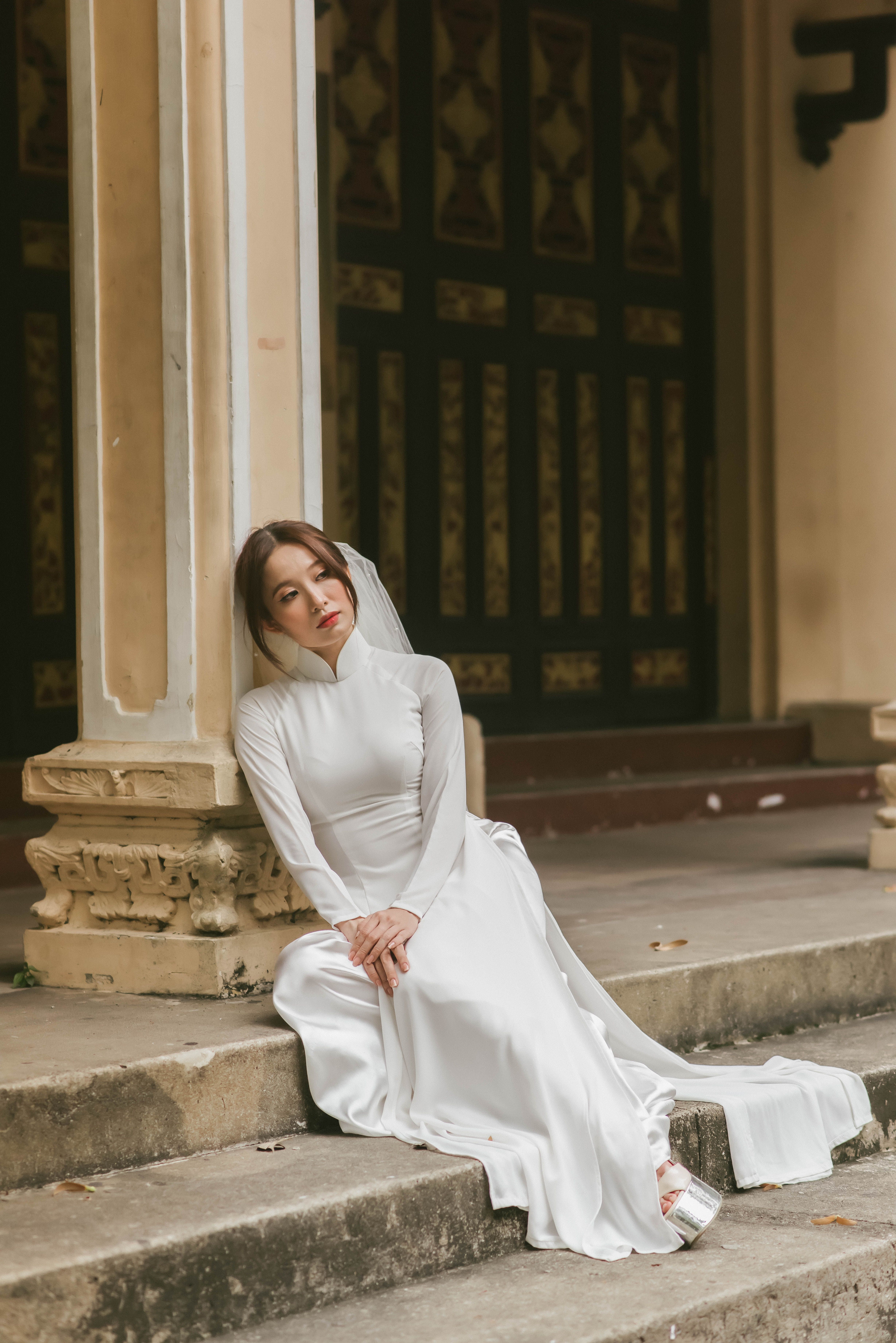 A Woman in White Long Sleeve Dress Sitting on the Stairs · Free Stock Photo