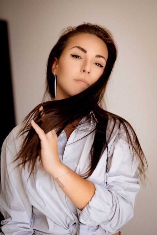 Free Elegant woman with brunette hair posing indoors, conveying confidence and style. Stock Photo
