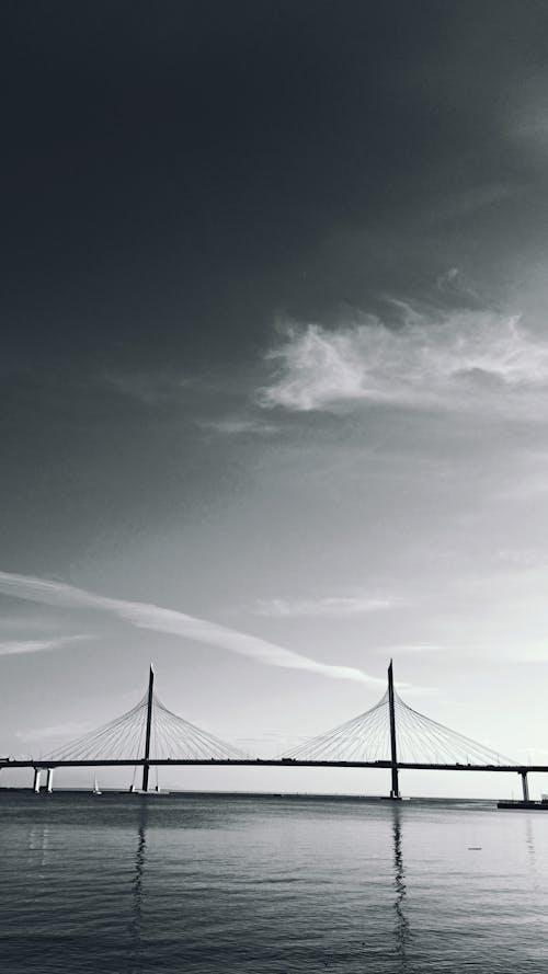 Gratis arkivbilde med bro, gråskala, solskinn skyway
