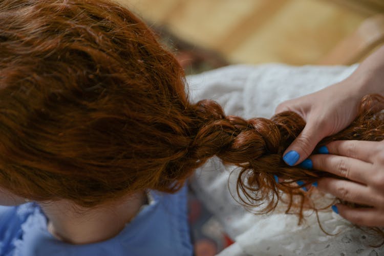 Hands Braiding A Woman's Hair