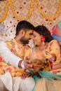 Man in White Sweater Kissing Woman in Yellow and White Floral Dress