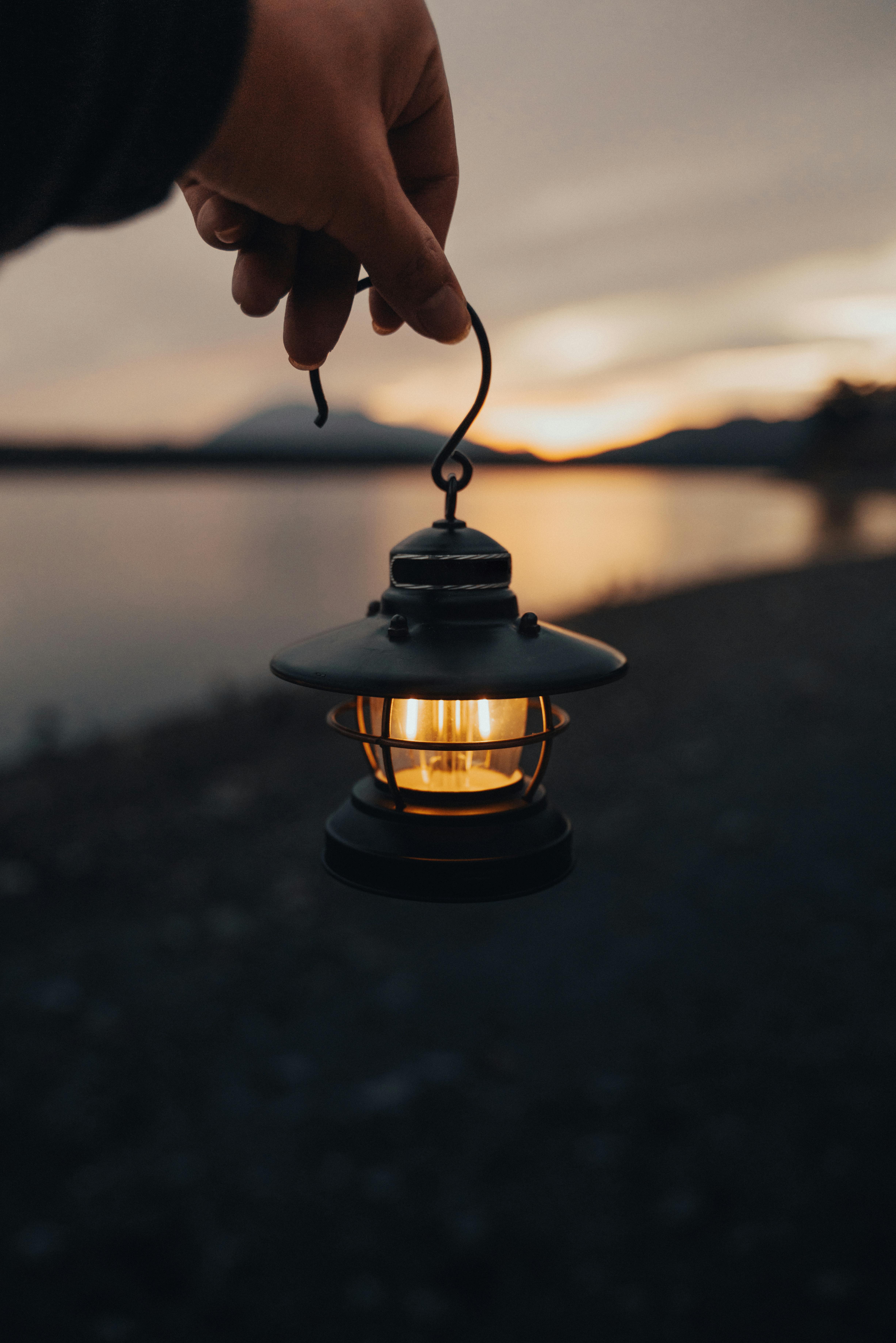 close up shot of a person holding a small lighted lantern