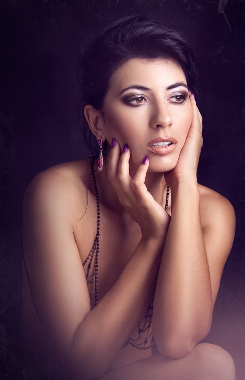 Free Captivating portrait of a woman with elegant jewelry, makeup, and a seductive pose. Stock Photo