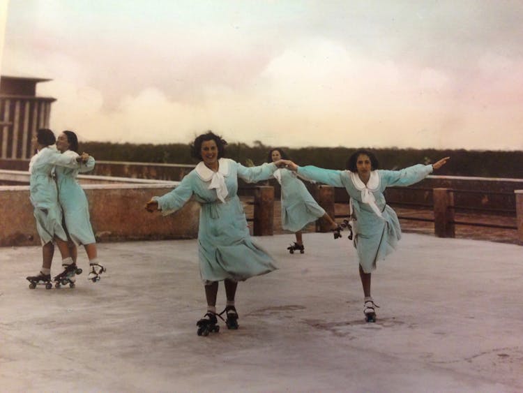 Woman In Vintage Clothing Dancing On Roller Skates